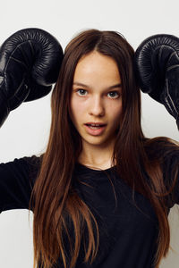 Portrait of smiling young woman against white background