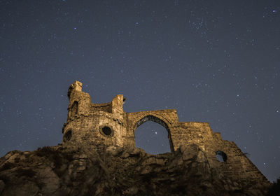 Old ruins of building against sky at night
