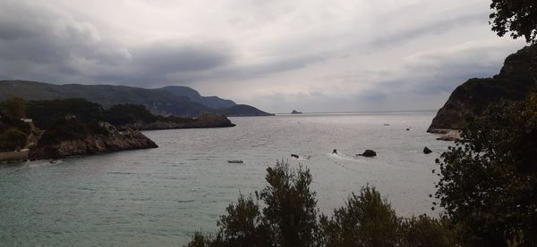 Scenic view of sea and mountains against sky