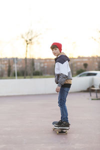 Full length portrait of boy standing on skateboard