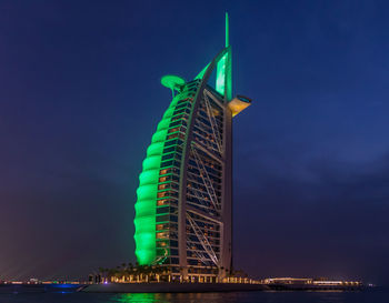 Low angle view of illuminated tower against sky at night