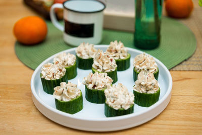 Cucumber canape stuffed with crab meat and cream cheese with walnuts on a plate