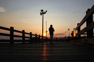 Pier over sea against sky during sunset