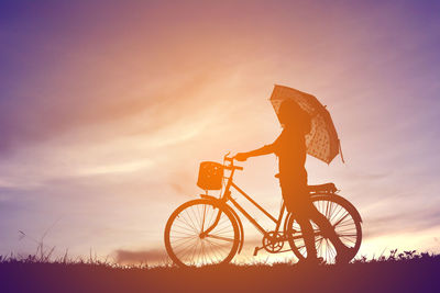 Silhouette woman with bicycle against sky during sunset