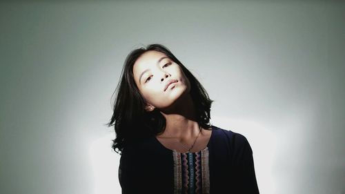 Young woman looking away over white background