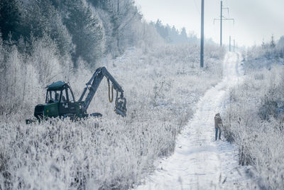 Road amidst trees on field during winter