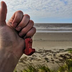 Close-up of person hand on beach