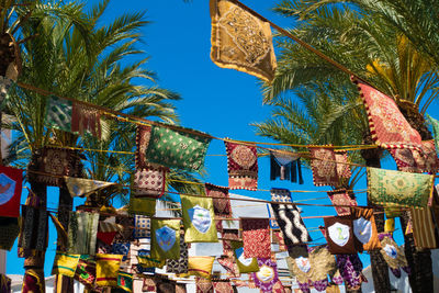 Low angle view of palm trees against blue sky