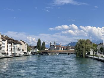 Bridge over river against buildings in city