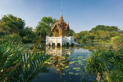 Temple amidst and trees lake against sky