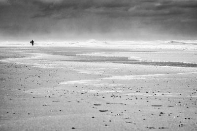 Surfer on lonely beach calling it a day