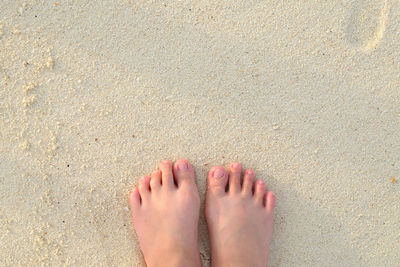 Low section of man standing at beach