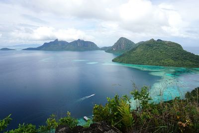 Scenic view of sea and mountains against sky