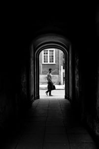 Man walking on footpath amidst building