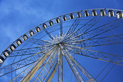 Low angle view of ferris wheel against blue sky