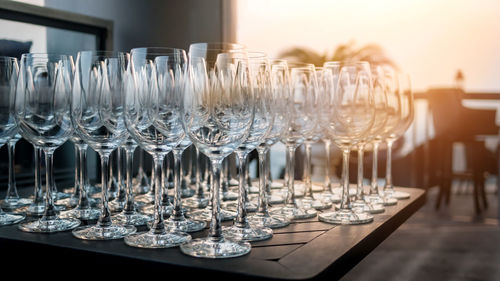 Close-up of wineglasses on table against sky during sunset