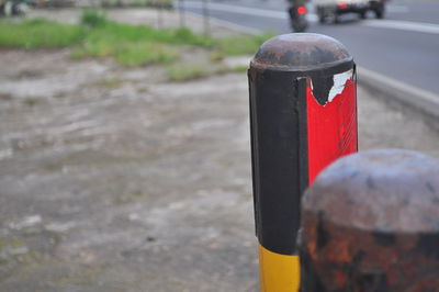 Close-up of red wooden post on road in city