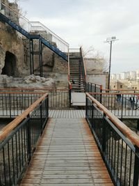 Footbridge by building against sky