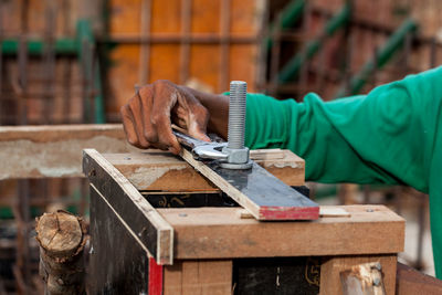 Cropped hand of carpenter working on wood