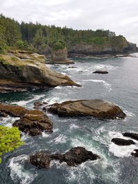 Scenic view of rock formation in sea against sky