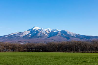 Scenic view of snowcapped mountains against clear blue sky