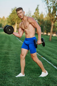 Low section of man exercising on field