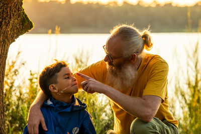 Father and son bonding at sunset lake