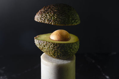 Floating avocado still life on a black marble background