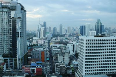 View of cityscape against cloudy sky