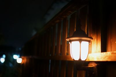 Close-up of illuminated lamp against sky at night