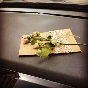 Close-up of flowers and envelop on seat