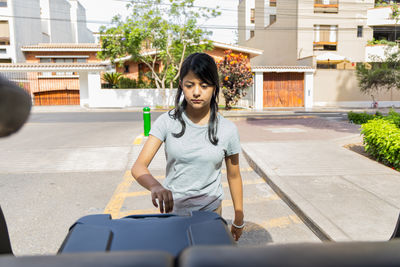 Portrait of young woman standing on street