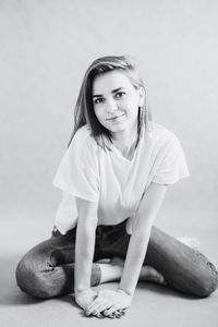 Portrait of a girl sitting against white background