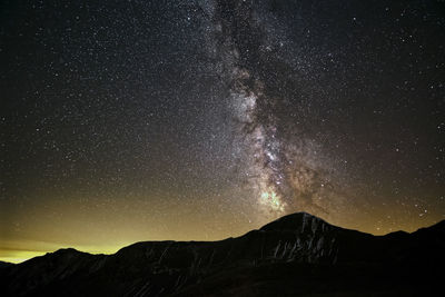 Scenic view of mountains against star field at night