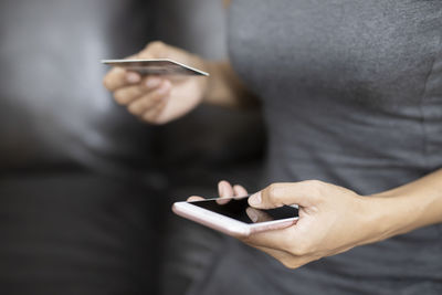 Midsection of man using mobile phone
