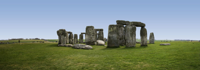 Old ruins on field against clear blue sky