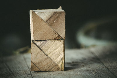 Close-up of  triangular pieces of wood arranged like a box on the table