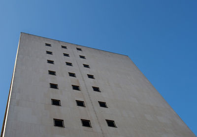 Low angle view of building against clear blue sky