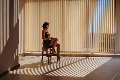 Side view of woman sitting on chair