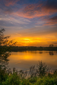 Scenic view of lake against orange sky