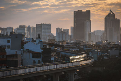 Illuminated buildings in city at sunset