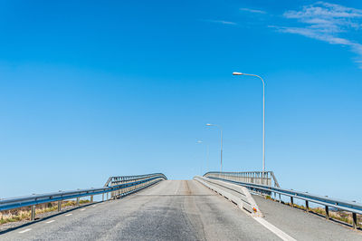 Bridge over highway against blue sky