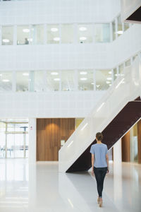 Young woman walking through building office hall