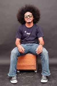 Portrait of young man sitting against wall