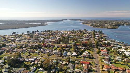 High angle view of townscape by sea against sky