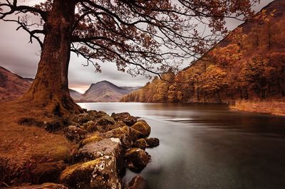 Scenic view of lake by mountain against sky