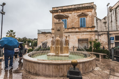 Fountain in the alberobello square on a rainy day, italy