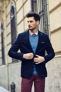 Young man standing against wall