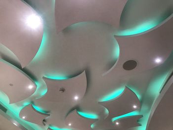Low angle view of illuminated lighting equipment on ceiling