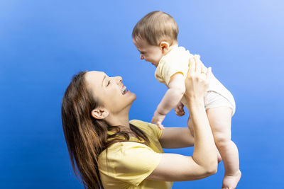 Mother and daughter against blue sky